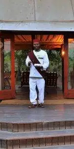 Tony Sparkes Wildlife & Photo Safaris - Hamiltons-Tented-Camp - Old Fashioned Nostalgia, blackman dressed up in old fashioned clothes and sash with fez.