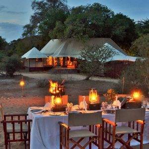 Tony Sparkes Wildlife & Photo Safaris - Hamiltons-Tented-Camp Outside Dining Table looking towards a tented reception area.