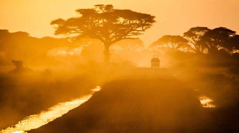Safety-&-Etiquette safari vehicle at sunset on a dusty road
