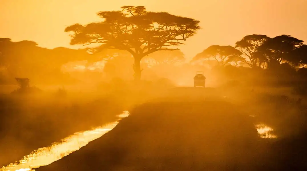 Safety-&-Etiquette safari vehicle at sunset on a dusty road